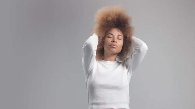 Mixed race black woman with big afro hair in studio alone