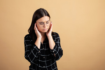 A young woman holding her temples. The girl has a headache.