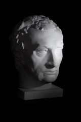 gypsum statue head greece on a black background with directional hard light