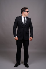 Full body shot of handsome Persian businessman with sunglasses
