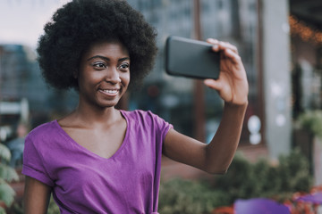 Fototapeta na wymiar Portrait of a smiling woman taking selfies on phne