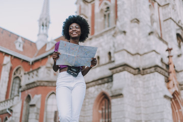 Low angle of a beautiful black woman holding city map