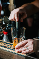 hand bartender make cocktail. Cocktail have orange and mint leaves.