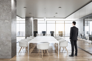 Businessman in bright concrete office interior