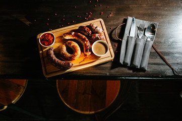 Oktoberfest food, appetizing meat sausages,. A large assortment on a wooden tray.