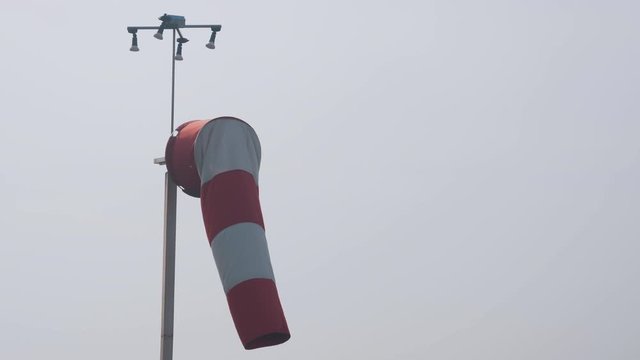Windsock in moderate wind against cloudy sky