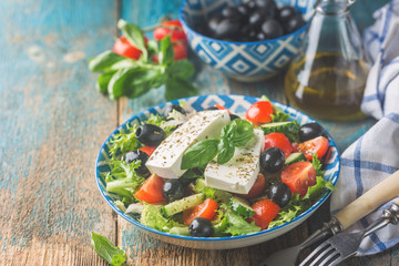 Fresh Greek salad of cucumber, tomato, sweet pepper, red onion, feta cheese and olives with olive oil. Healthy food