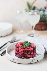 Russian beetroot salad vinaigrette in a white plate over light background