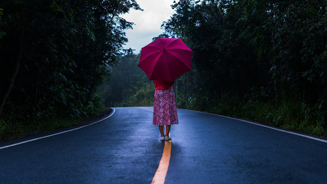 silhouette woman standing with an umbrella to prevent rain on a rainy day
