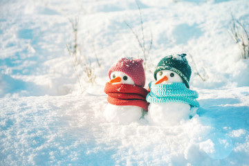 Two small snowmen the girl and the boy on snow, copy space. Greeting card for lovers, Christmas card