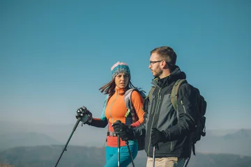 Tuinposter Couple hikers on a mountaintop © Suteren Studio