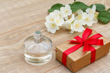 Obraz na płótnie Canvas Gift box with perfume and jasmine flowers on the background.