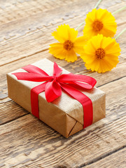 Gift box on wooden boards with flowers