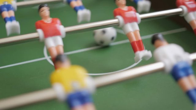 Friends Playing Table Soccer Game Closeup. People playing in table football or kicker with miniature players. Slow Motion. Shallow DOF. Playing Football Soccer on game table. Close Up.