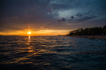 Fototapeta na wymiar Zadar, Croatia - July, 2019: Sunset in Zadar promenade, Croatia