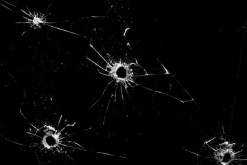 holes in the glass with cracks isolated on a black - obrazy, fototapety, plakaty