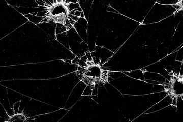 holes in the glass with cracks isolated on a black