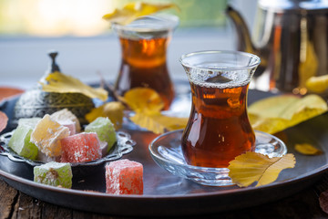 Glass Cup of turkish tea served in traditional style with summer outdore view