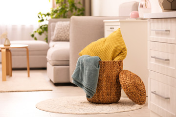 Basket with blanket and pillow in light room