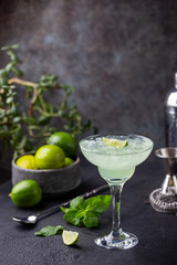 margarita cocktail with lime in a glass on dark background