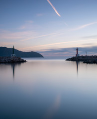 Fototapeta na wymiar Sunrise Cala Bona Harbour Majorca with silky smooth flat sea and beautiful reflections in the water.