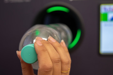Junge Frau wirft Pfandflaschen in Automaten