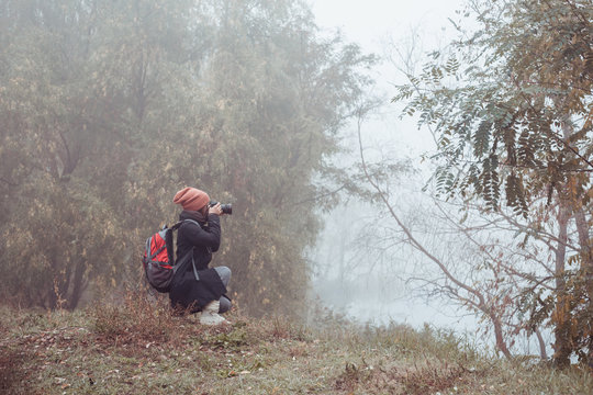 Girl photographer takes pictures of autumn nature. 