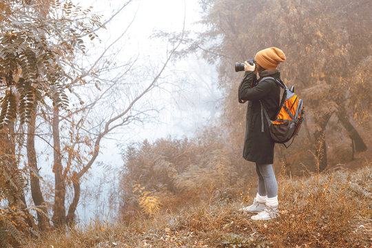 Girl photographer takes pictures of autumn nature. 