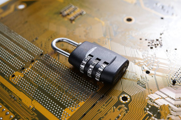 Padlock lying on PC Mainboard symbolizing Computer Cyber Security Concept