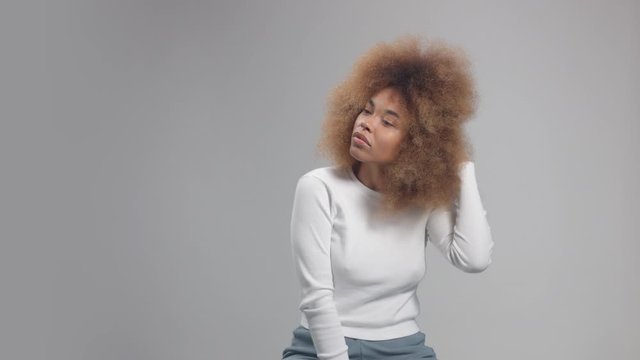 Mixed race black woman with big afro hair in studio alone