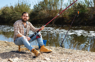 Bearded fisherman fishing on weekend in the river