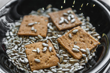 wheat crackers shooted with different  vegetables,groats,honey,seeds,salt on different surfaces