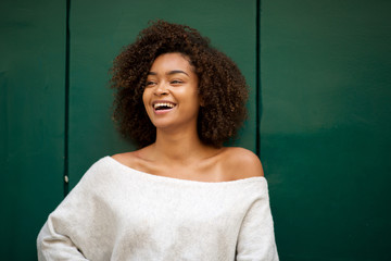 laughing young african american woman against green background