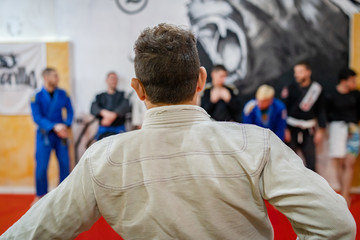 Brazilian jiu jitsu training BJJ instructor standing in front of the line of his students at the...