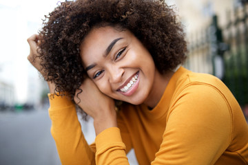 Close up young african american woman smiling with curly hair - Powered by Adobe
