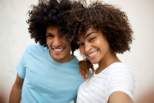 Close up happy african american couple taking selfie by white background