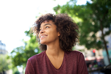 Close up smiling african American girl with curly hair looking away