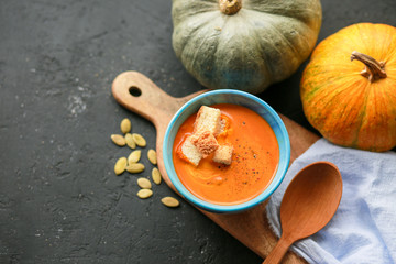  Vegetarian autumn pumpkin cream soup with seeds. Seasonal autumn food - pumpkin soup with thyme. Pumpkin soup with herbs, cream, breadcrumbs and parmesan, served in a bowl, top view. Place for text