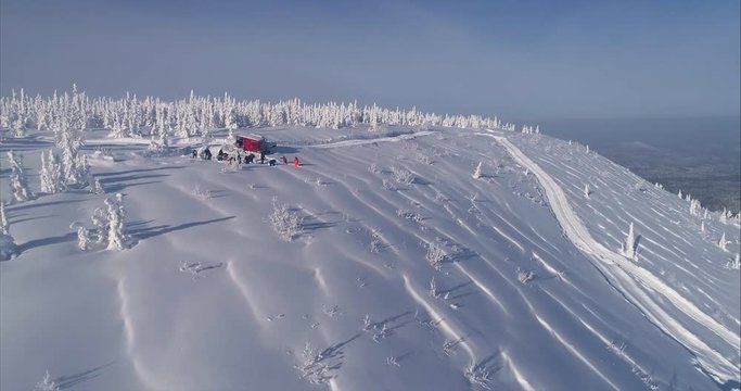 Aerial shot: snow cat during a day of cat skiing. Epic snowy mountains with Snow groomer. Freeride vacation and snowboarding in mountains ski resort. transfer by snowcat freeride. 4k footage.