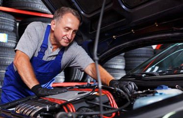Plakat man mechanic engaged in car repair