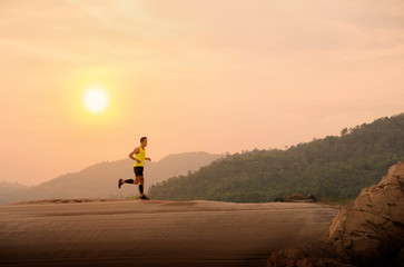 runner on rural track with sunset or sunrise, sport and healthy concept