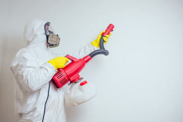 pest control worker spraying pesticides with sprayer in apartment copy spase white walls background