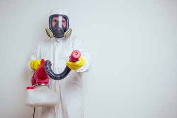 pest control worker spraying pesticides with sprayer in apartment copy spase white walls background