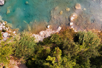 Top view of azure lake with green coast. Beautiful water body captured from drone. Aerial view of picturesque landscape with crystal clear pond. Summer vacation concept. Wild nature paradise