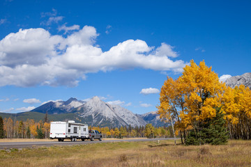 An RV aon the highway through the Canadian Rocky Mountains in Kananaskis, Alberta, Canada during the peak of autumn colors