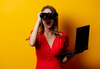  woman in red dress with binocular and laptop computer