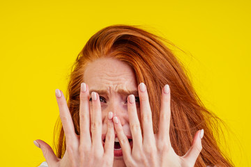 ungroomed nervous unhappy young redhaired ginger woman looking at a broken fingernail and crying...