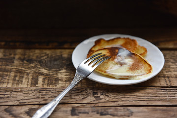 pancakes with condensed milk on a wooden table