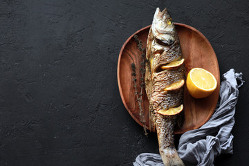  Baked fish with lemon and herbs. Dorado on a plate with vegetables. Tasty fried dorado fish or...