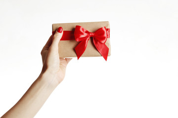 Gift box in a female hand on white